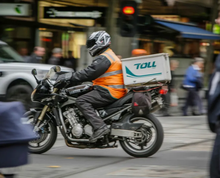 Person in a hi-vis vest riding a motorcycle on the road