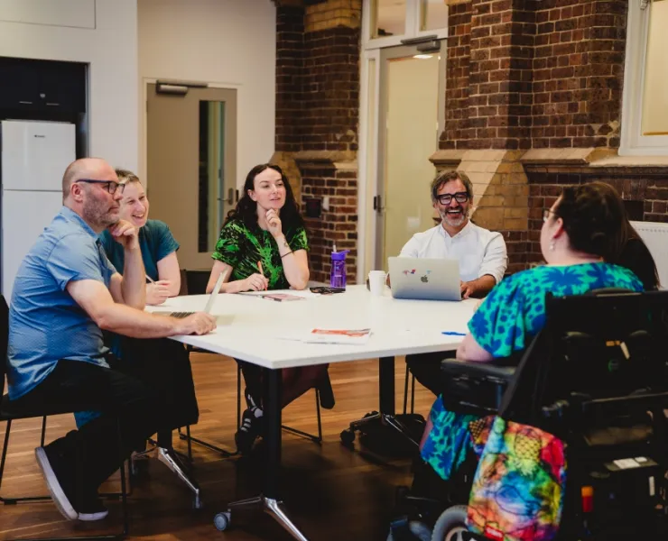 Group of people sitting at table having a meeting in Library meeting room