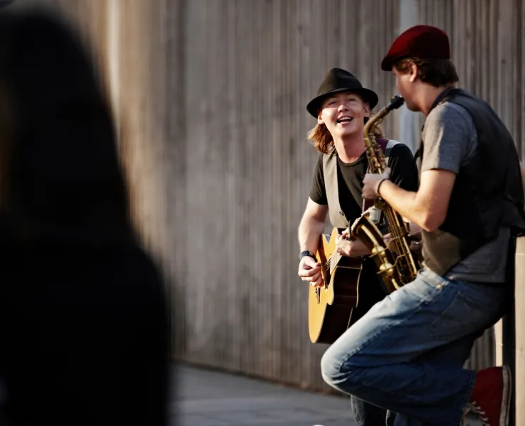 A guitarist and a saxophonist perform on a street in Southbank, Melbourne CBD.