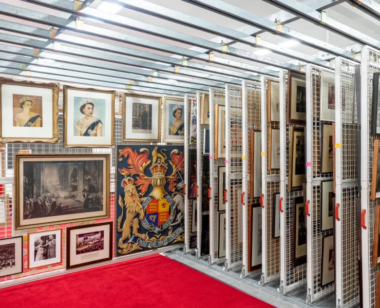A room filled with various framed pictures on display on a storage rack 