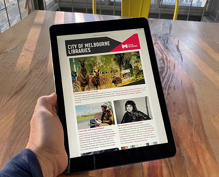 Person reading libraries newsletter on a tablet screen