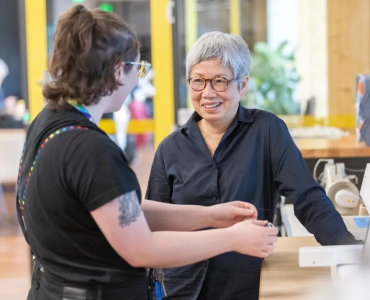 Library staff talking to asian woman