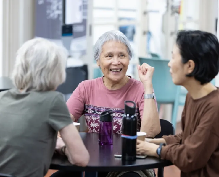 Three older woman drinking beverages at City Baths table