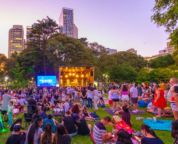 A large crowd at an outdoor event in a park.