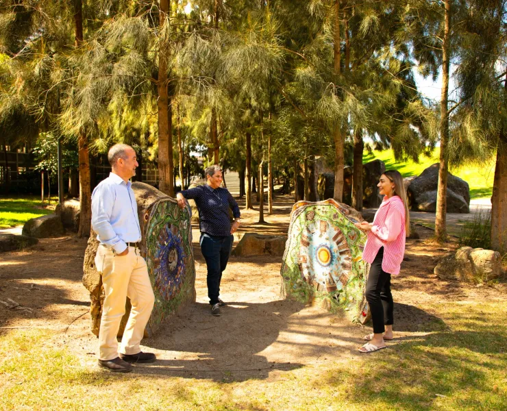 Three people in a park having a conversation.