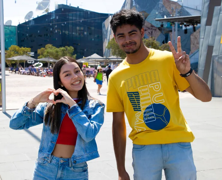 Two international students pose together in Federation Square.