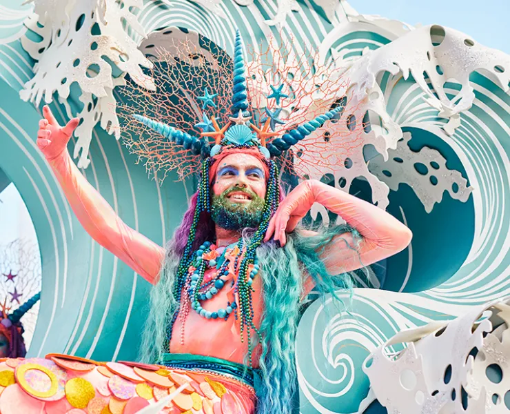 Someone in a mer-person costume on a parade float