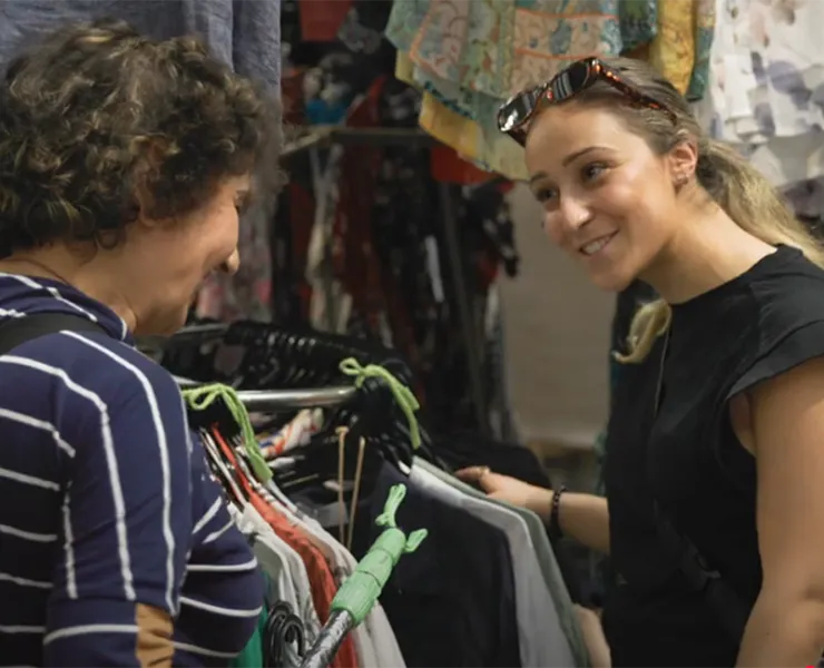 Two smiling women at market stall