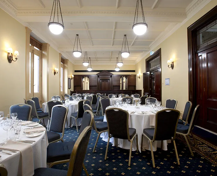 Interior of ornateroom with multiple tables set up for dining.