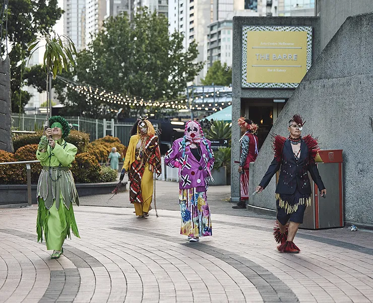 Five people in colourful outfits.
