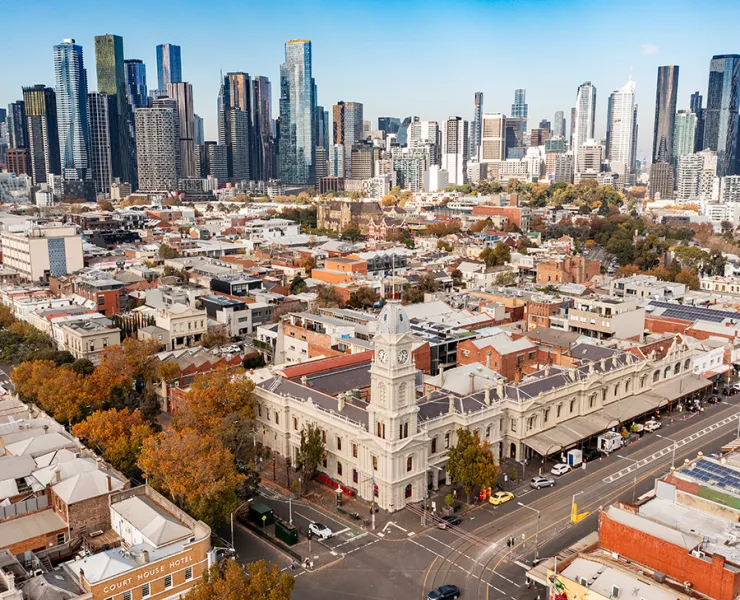 Aerial view of North and West Melbourne, with town hall in the foreground and CBD high-rises in the distance.