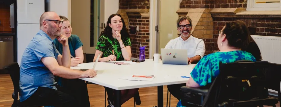 Group of people sitting at table having a meeting in Library meeting room