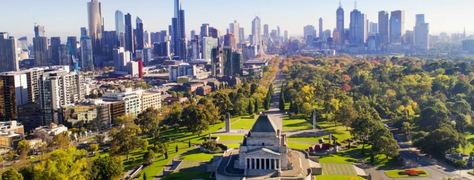 Birds-eye view over a shrine in the middle of a park and city skyline