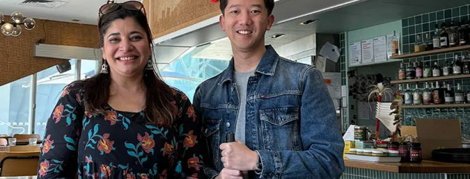 Two people in a restaurant smiling