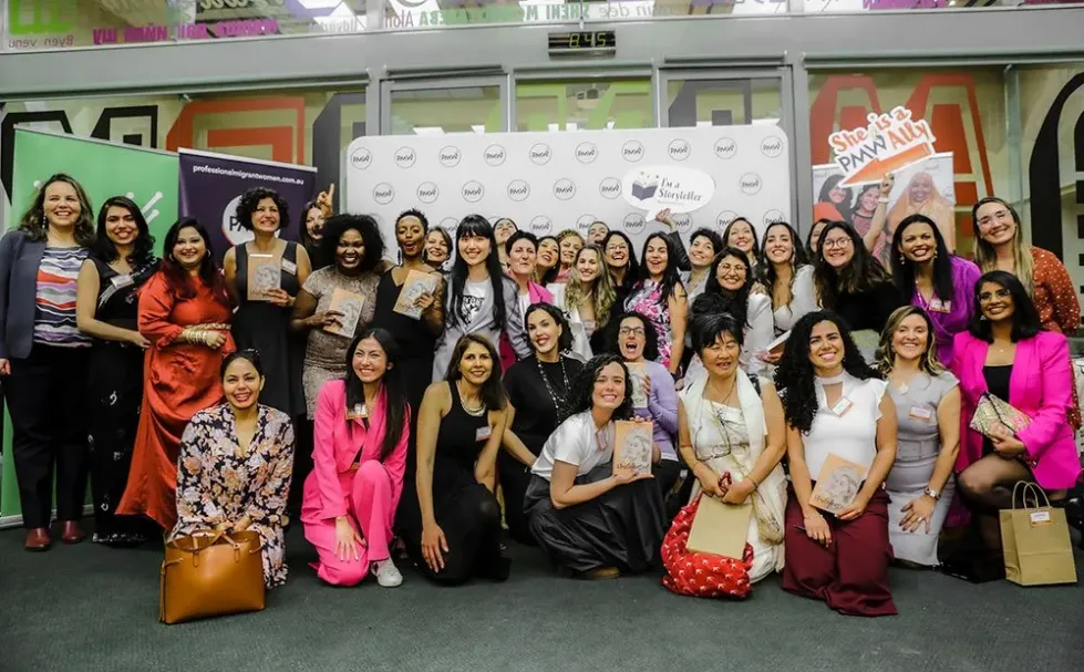 A large group of women of many nationalities, several holding the Undefeated book.