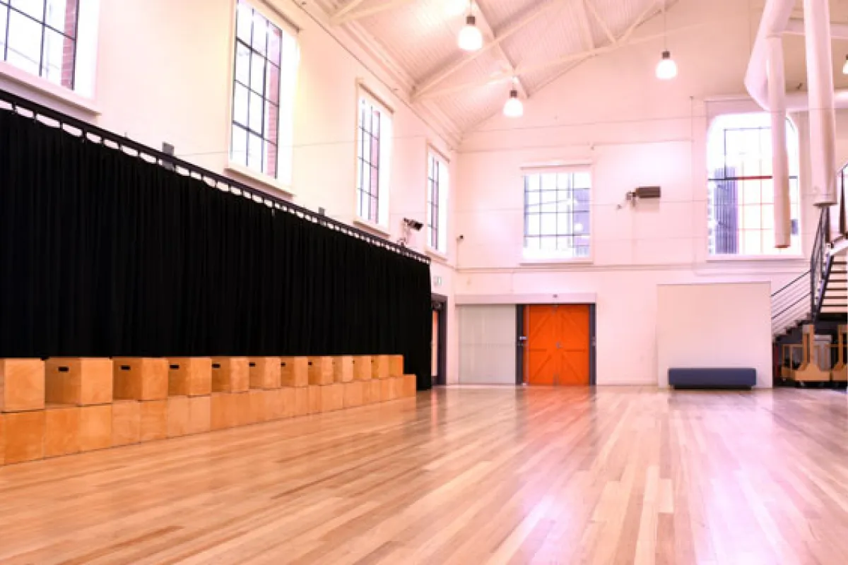 Large hall with high ceilings and a black curtain along the wall