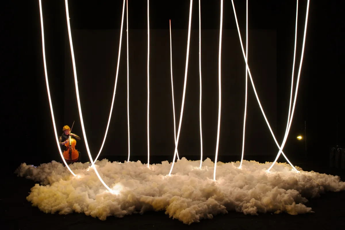 Clouds on a stage with hanging illuminated loops and cell player