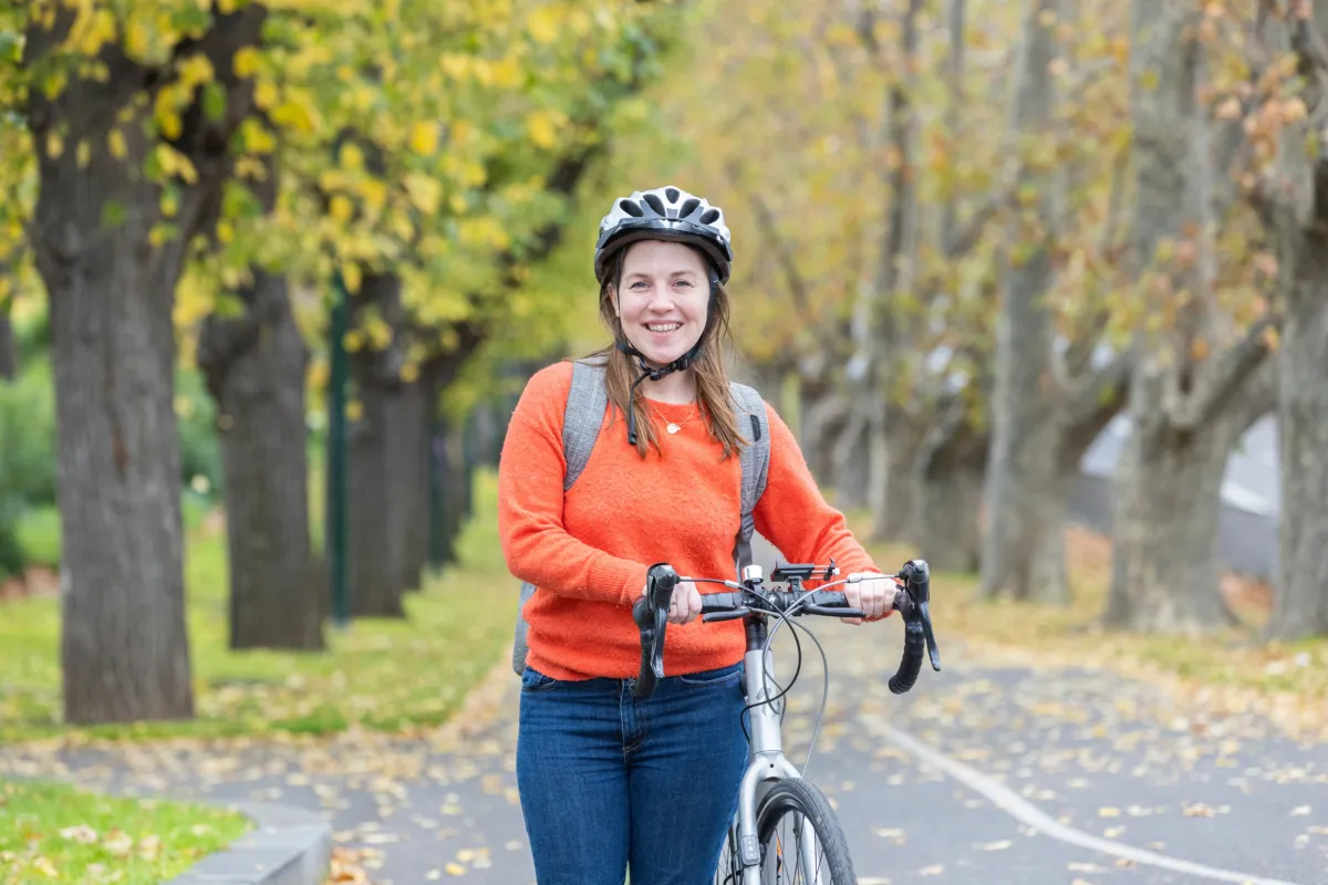Person with bike helmet holding a bike on Alexandra Avenue.