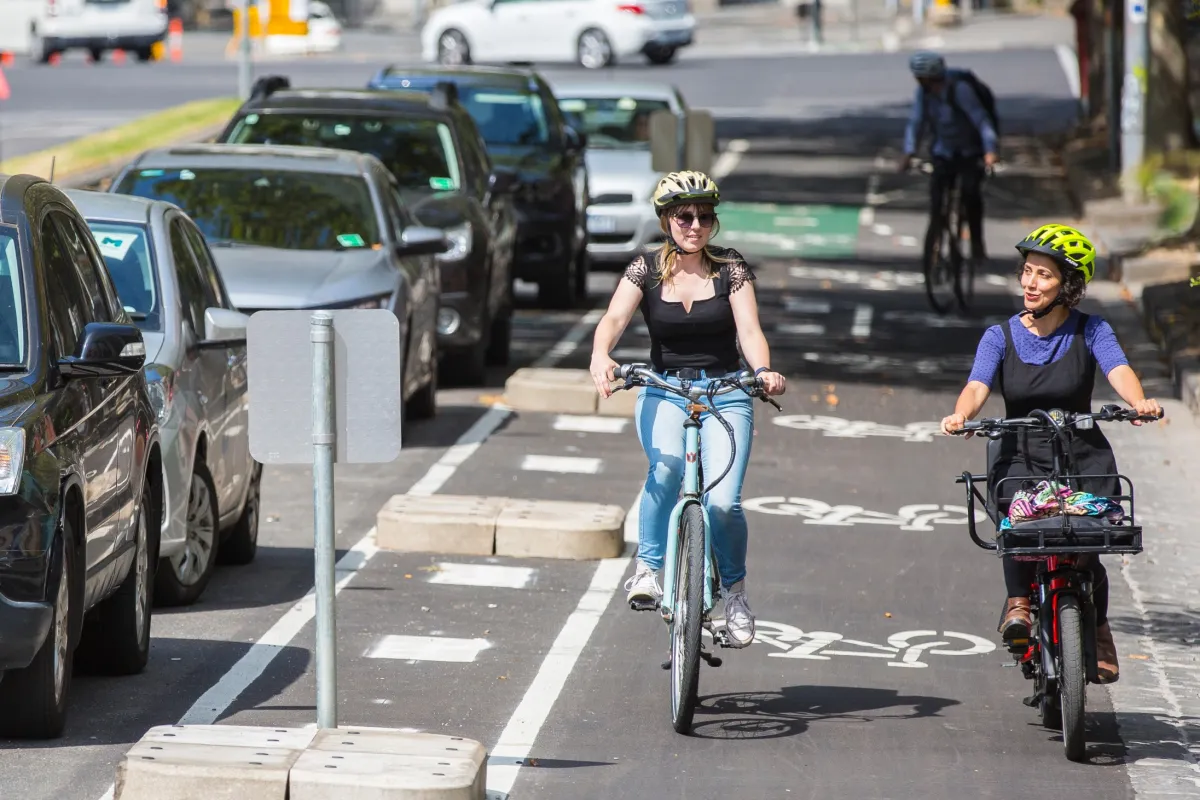 Two cyclists riding bikes on Rathdowne Street.