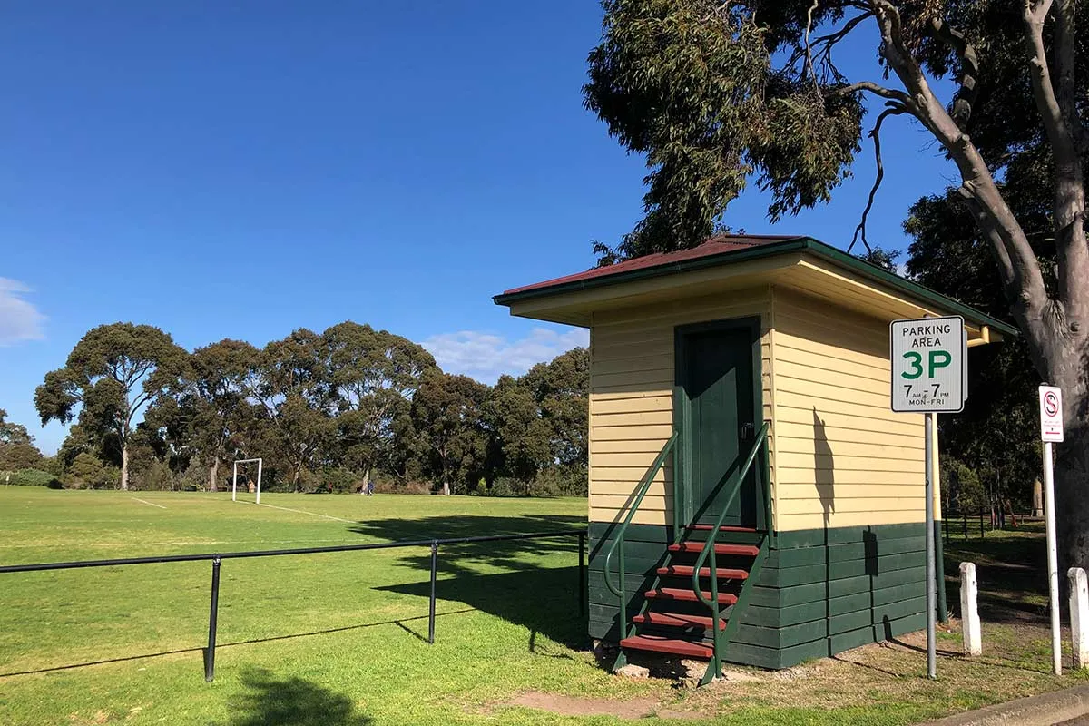 A small building next to a sporting oval