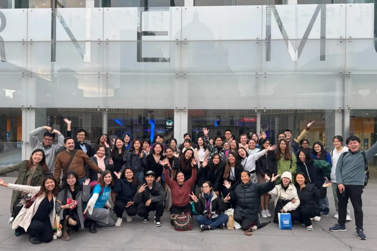A group of people posing outside a museum bulding