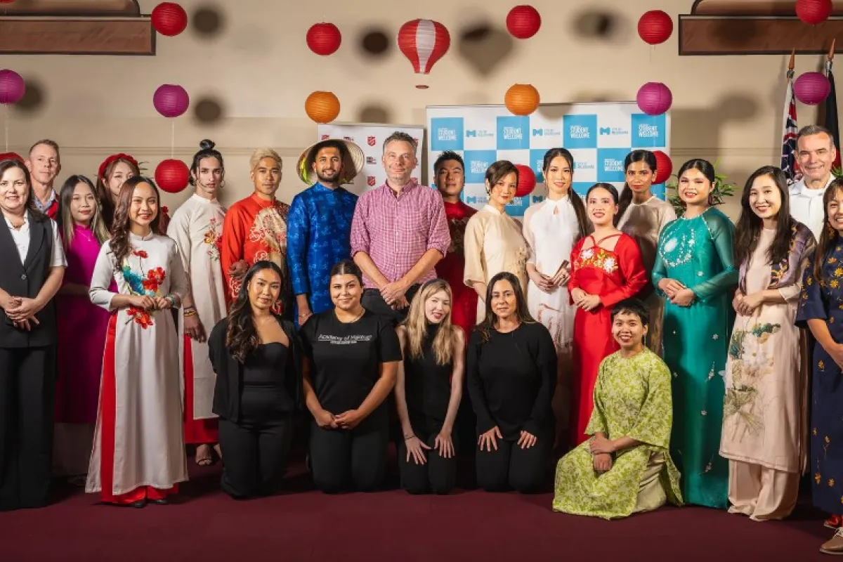 A group of people wearing colourful formal dress pose for the camera